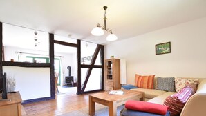A cozy living room with a sofa, wooden coffee table, and a fireplace. - Spacious Holiday Home in Landstorf Zierow near Beach (Zierow)