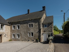A stone building with a gravel driveway and a narrow road. - Sprimont Sauna & Garden Stay (Sprimont)