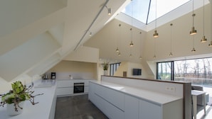 A modern kitchen with a large island, built-in appliances, and pendant lighting. - Lovely Holiday Home 'walleken' With a Pond (Aalst)