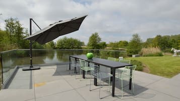 Enjoy al fresco dining in a serene setting with a table and comfortable chairs.
