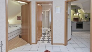 A room with a bed, a bathroom with a toilet and sink, and a kitchen area with a stove and cabinets. - Furnished Apartment in Nieheim Germany near Forest (Nieheim)