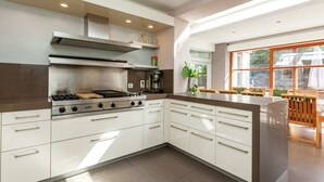 Una cocina moderna con una isla central, horno empotrado y cafetera.