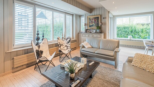 Un salon spacieux avec une grande fenêtre, un canapé, une table basse et une cheminée.