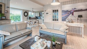Un salon moderne comprenant un canapé, une table basse et un coin repas avec des chaises et une table.