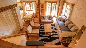 A spacious living area with a sofa, chairs, a coffee table, and a dining table. - Cosy and Snug Holiday Home With Joint Swimming Pool (Tessenderlo)