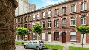 A row of brick townhouses with a car parked in front. - Holiday Home in Kortrijk for 8 Person (Kortrijk)