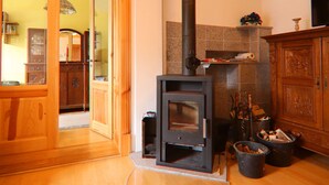 A wood-burning stove in a room with wooden floors and cabinets. - Alt Krassow Lakeside Retreat (Lalendorf)