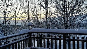A snow-covered wooden deck with a lantern post. - House in Bohemian Near Ski Slope (Blatno)