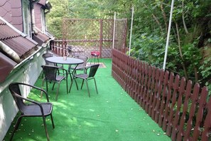 Enjoy casual dining or meetings in this serene garden setting surrounded by lush foliage and a traditional building.