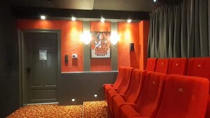 A cinema room with red seats, a patterned carpet, and a Star Wars poster on the wall. - Gruppenhaus mit German Heimkino, 18 Personen (Treuen)
