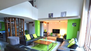 A modern living room with a pool table, sofas, and a television. - Rustic Farmhouse With Pool (Waimes)