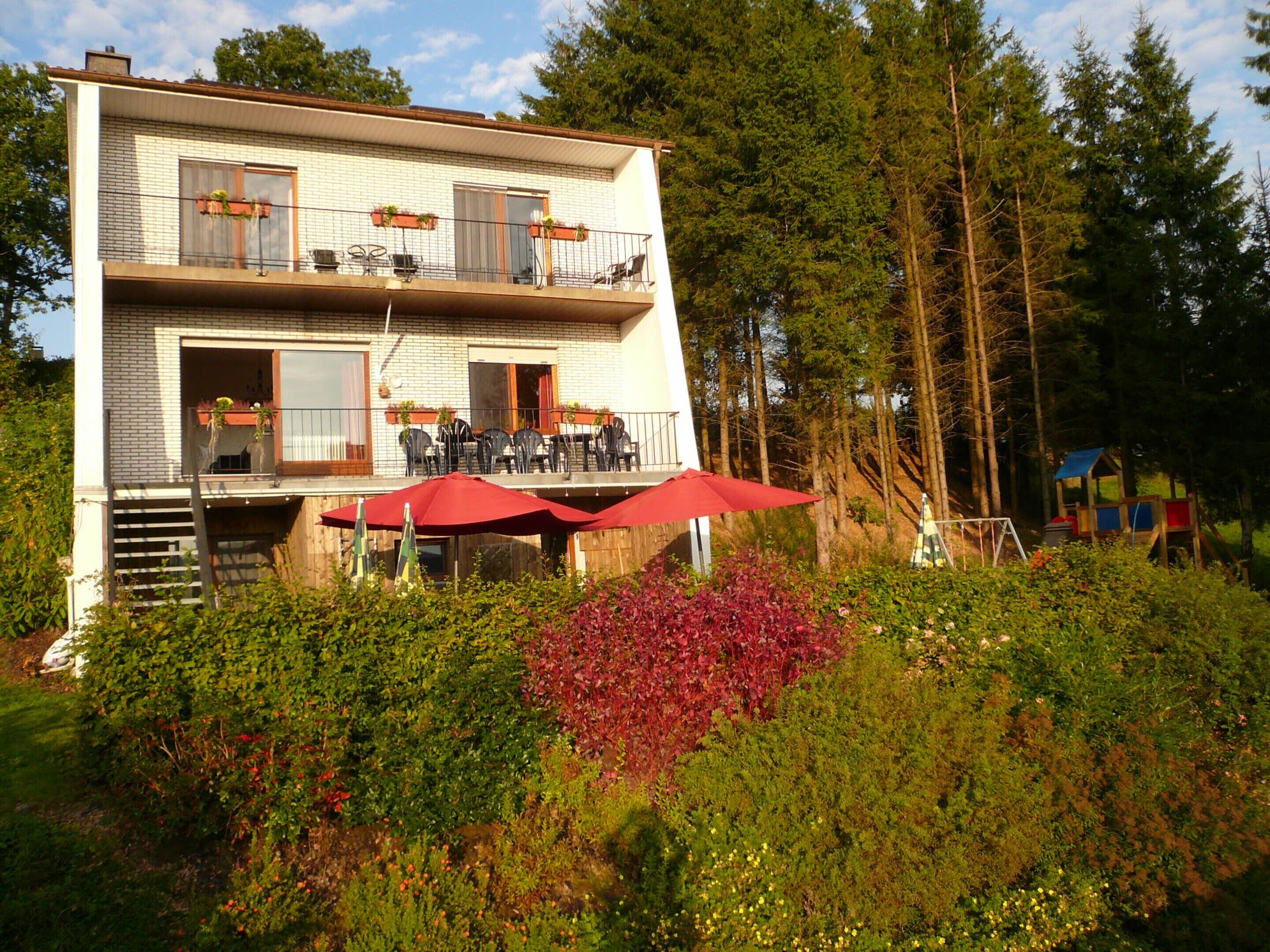 Een gebouw met twee verdiepingen, een balkon en een terras.
