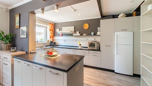 A modern kitchen with white cabinets, a central island, and a Bosch refrigerator. - Pretty House in the Ardennes With Swimming Pool & Games Room (Waimes)