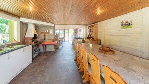 A spacious kitchen with a long wooden table, a built-in oven, and a large window. - Pretty House in the Ardennes With Swimming Pool & Games Room (Waimes)