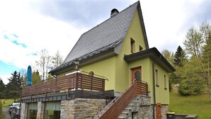 A stone building with a wooden staircase and a metal railing. - Mountain Hideaway in Wildenthal (Eibenstock)