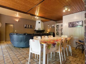 Un comedor con una mesa preparada para cuatro, un sofá azul y un letrero en la pared que dice 'PARIS'.