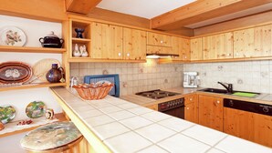 A kitchen with wooden cabinets, a stove, a dishwasher, and various kitchenware.