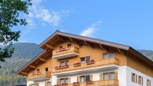 Un hotel de varios pisos con balcones de madera y macetas con flores.