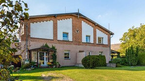 A two-story brick house with a covered porch, a well-maintained lawn, and a stone pathway leading to the entrance. - Apartment in Wittenbeck Near Baltic Sea (Wittenbeck)
