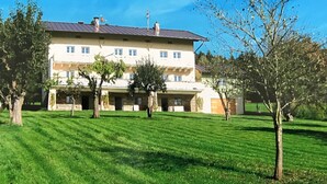 A large, multi-story building with a flat roof, surrounded by a well-maintained lawn and several trees. - Spacious Villa near Forest in Buchet (Lam)