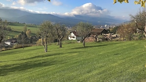 A rural landscape with a house, trees, and distant mountains. - Spacious Villa near Forest in Buchet (Lam)