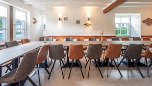 A conference room with a long table, multiple chairs, and a high ceiling with exposed beams. - Holiday Home With Sauna in the Eifel National Park (Schleiden)