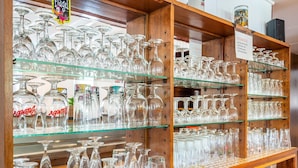 A display of various glassware including wine glasses, water glasses, and bottles, arranged on shelves and a counter. - Holiday Home With Sauna in the Eifel National Park (Schleiden)