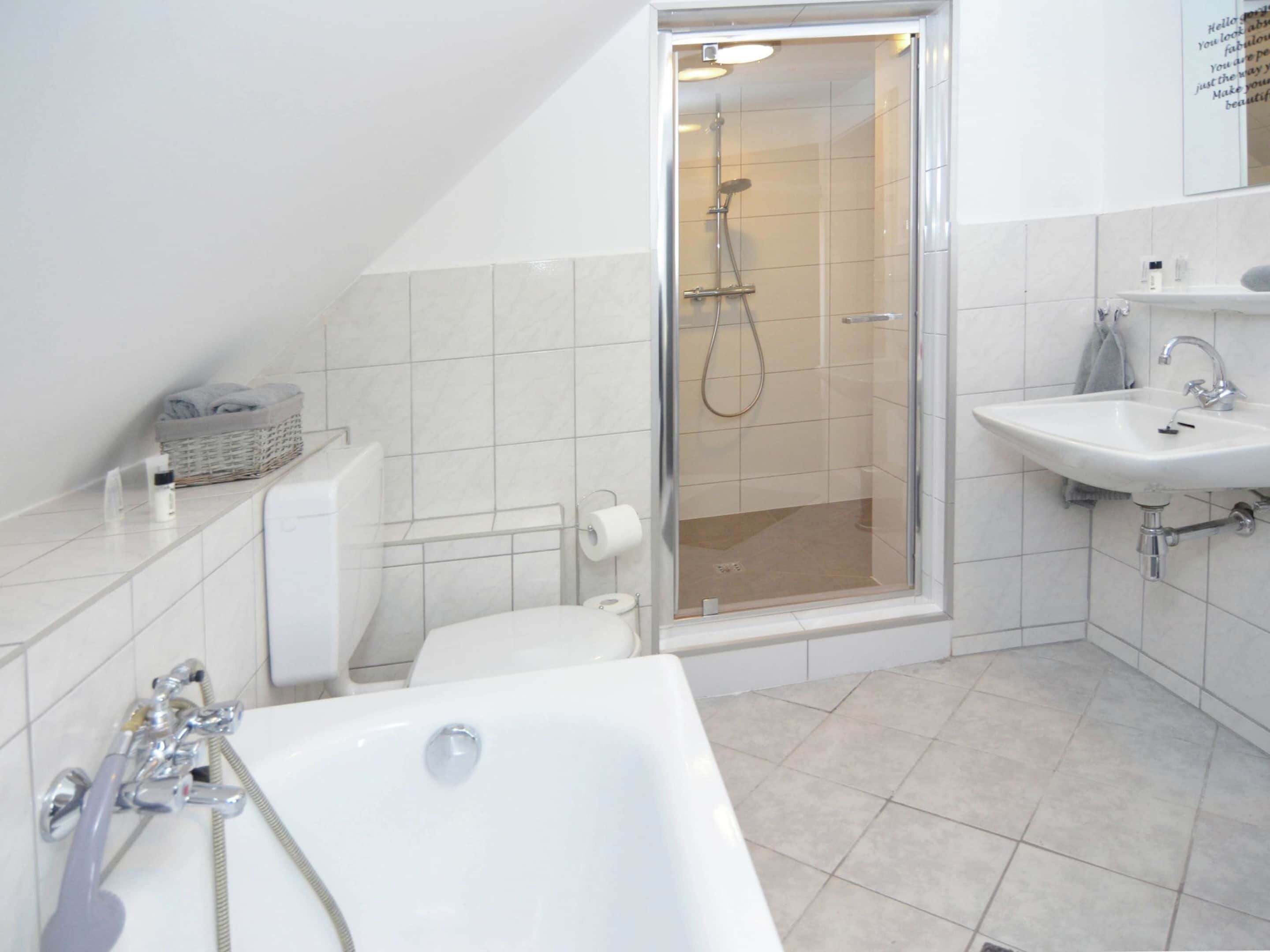 A modern bathroom with a shower, toilet, and bathtub.