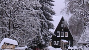 A snow-covered building with a sign indicating it is a hotel. - Forest-edge Braunlage Home (Braunlage)