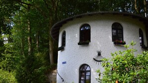 A white building with three arched windows, a small balcony with flowers, and a sign reading "Sonnenberg". - Strotzbusch Forest Hideaway (Strotzbusch)