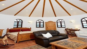 A spacious room with a high, star-shaped ceiling, wooden furniture, and large windows. - Strotzbusch Forest Hideaway (Strotzbusch)