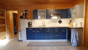 A modern kitchen with blue cabinets, a stainless steel range hood, and a tiled backsplash. - Quaint Apartment in Umhausen near Ski Area (Umhausen)