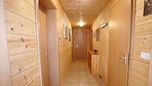 A narrow hallway with wooden walls and a tiled floor, leading to a door at the end. - Quaint Apartment in Umhausen near Ski Area (Umhausen)
