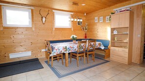 A wooden interior with a dining table, chairs, a bench, a cabinet, and a wall-mounted deer skull. - Quaint Apartment in Umhausen near Ski Area (Umhausen)