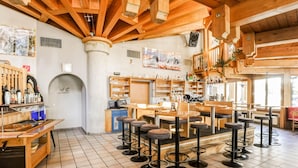 A bar area with wooden furniture, tiled flooring, and a variety of bottles and glasses on shelves. - Apartment in Langenfeld Near Solden Ski Lift (Laengenfeld)