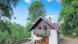 A two-story house with a wooden balcony, a brick chimney, and a gravel driveway. - Mountains Family Retreat (Rudník)