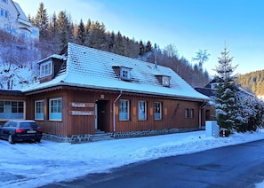 A wooden building with a sign reading 'Sorglich Willkommen' and a car parked in front. - Ferienwohnung im Oberharz in Wildemann (Clausthal-Zellerfeld)
