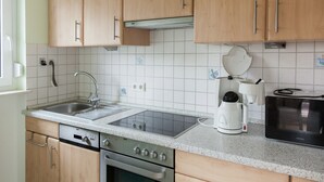 Keittiössä on puukuvioiset kaapit, ruostumattomasta teräksestä valmistettu pesuallas, sisäänrakennettu uuni, kahvinkeitin ja mikroaaltouuni.