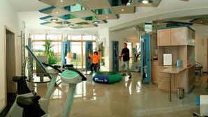 A gym with cardio machines, a rowing machine, and a green exercise ball. - Alpine View Wellness Escape (Waldkirchen)