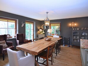 A dining area with a wooden table and chairs, a chandelier, and a cabinet with dishes. - Quaint Holiday Home near Ski Area in Neuastenberg (Winterberg)