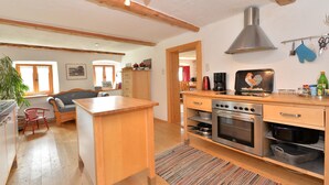 Une cuisine avec des meubles de rangement en bois, une cuisinière et une machine à café.
