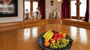 Une table à manger avec un saladier de fruits au centre.