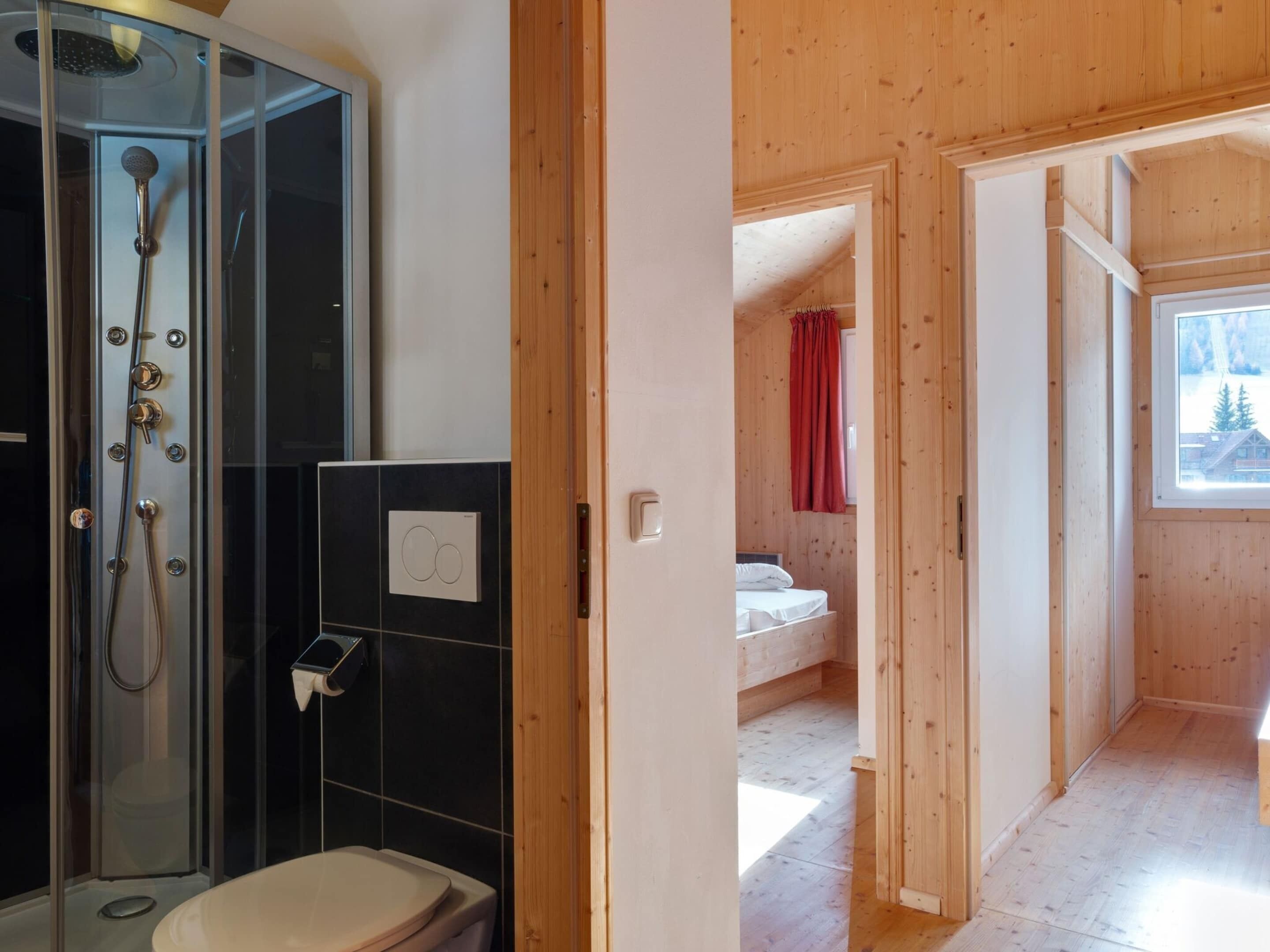 Ein Badezimmer mit Duschkabine, Toilette und Bedienfeld.