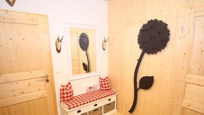 Un intérieur en bois avec un banc, des décorations murales et une porte.