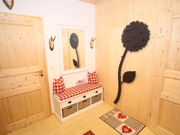 A wooden interior with a bench, wall-mounted decorations, and a door. - Cozy Chalet in Hohentauern near Ski Area (Hohentauern)