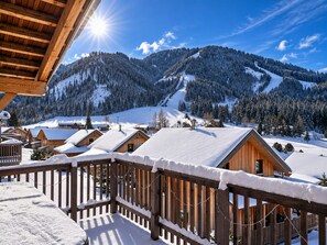 A wooden cabin with a balcony, surrounded by snow-covered mountains and a clear sky. - Cozy Chalet in Hohentauern near Ski Area (Hohentauern)