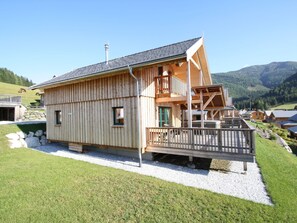 A wooden chalet with a balcony, a chimney, and a view of the surrounding mountains. - Cozy Chalet in Hohentauern near Ski Area (Hohentauern)