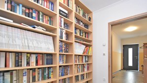 Una biblioteca con varias estanterías de madera llenas de libros.