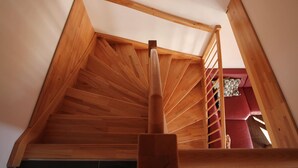 Una scala in legno con corrimano che porta a un piano superiore.
