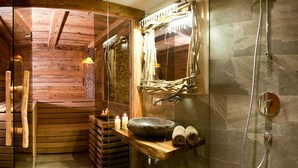 A wooden interior with a stone sink, a shower, and a mirror. - Fürsten Chalet (Flachau)